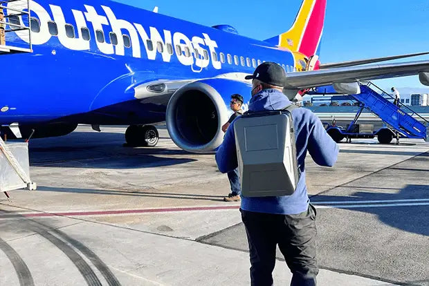 Guy on an airport tarmac about to board a Southwers flight while carrying a Cyberbackpack.