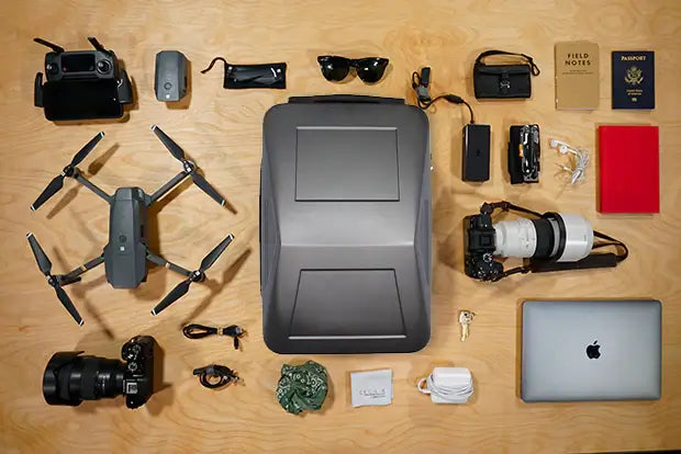 Cyberbackpack flatlay with drones, camera and all the gear that can be carried within the bag.