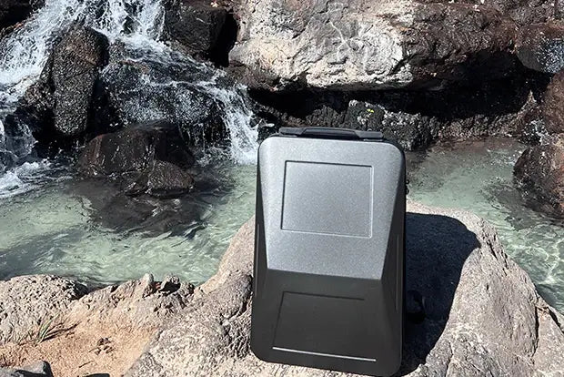 A Cyberbackpack next to a body of water to represent how to wash and clean a backpack.